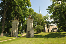 The park is entered through a fragment of a Baroque palace gate dating from the 18th c., flanked by two pillars decorated with rustication and crowned with vases. Two 16th-c. Renaissance sandstone epitaph plaques have been embedded in the pillars with the reliefs of human figures